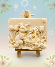 Load image into Gallery viewer, Intricate handmade soap scene from Soap Simple Creations featuring an Easter bunny, chicks, and tulips, displayed on a wooden easel with spring flowers. Vegan and cruelty free soap. 
