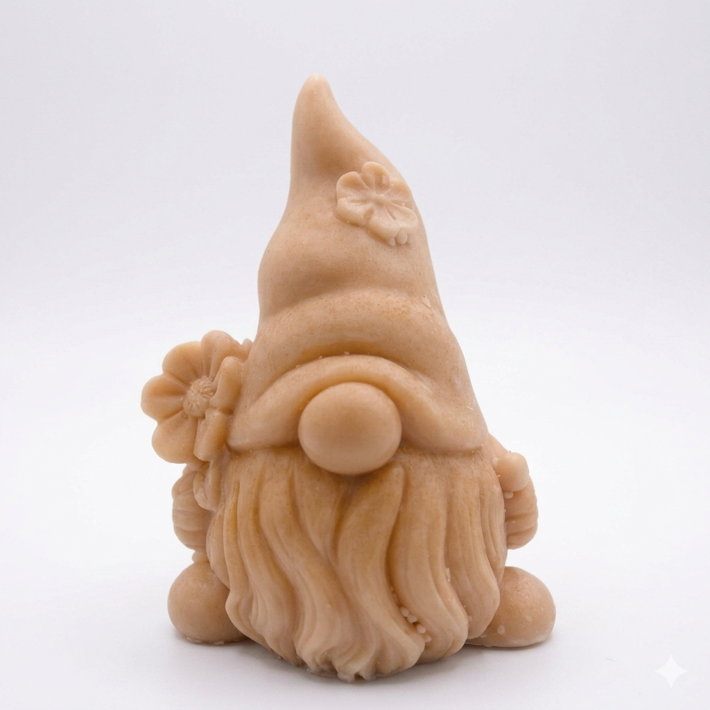 A 3D handmade vegan soap in a warm cream tone, sculpted into a cute garden gnome or gonk with a long flowing beard, a large round nose, and a tall pointed hat adorned with small embossed flowers.