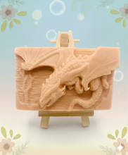 Load image into Gallery viewer, Dragon gift. Dinosaur gift. Our Flying Dragon soap features a striking dragon with its majestic wings spread wide, symbolising freedom and power. This artisan bar is vegan, cruelty-free, and designed with care for both your skin and the planet. Available in your choice of colour and essential oil. Each soap comes beautifully wrapped in eco friendly packaging. zero waste gift. kodern gift ideas. handmade home style. eco conscious home. eco friendly gifts. go green home. 
