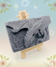 Load image into Gallery viewer, Dragon gift. Dinosaur gift. Our Flying Dragon soap features a striking dragon with its majestic wings spread wide, symbolising freedom and power. This artisan bar is vegan, cruelty-free, and designed with care for both your skin and the planet. Available in your choice of colour and essential oil. Each soap comes beautifully wrapped in eco friendly packaging. zero waste gift. kodern gift ideas. handmade home style. eco conscious home. eco friendly gifts. go green home. 
