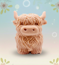 Load image into Gallery viewer, Large handmade vegan soap in the shape of a fluffy Highland cow calf with a detailed, shaggy coat, displayed against a whimsical farmhouse decor background.
