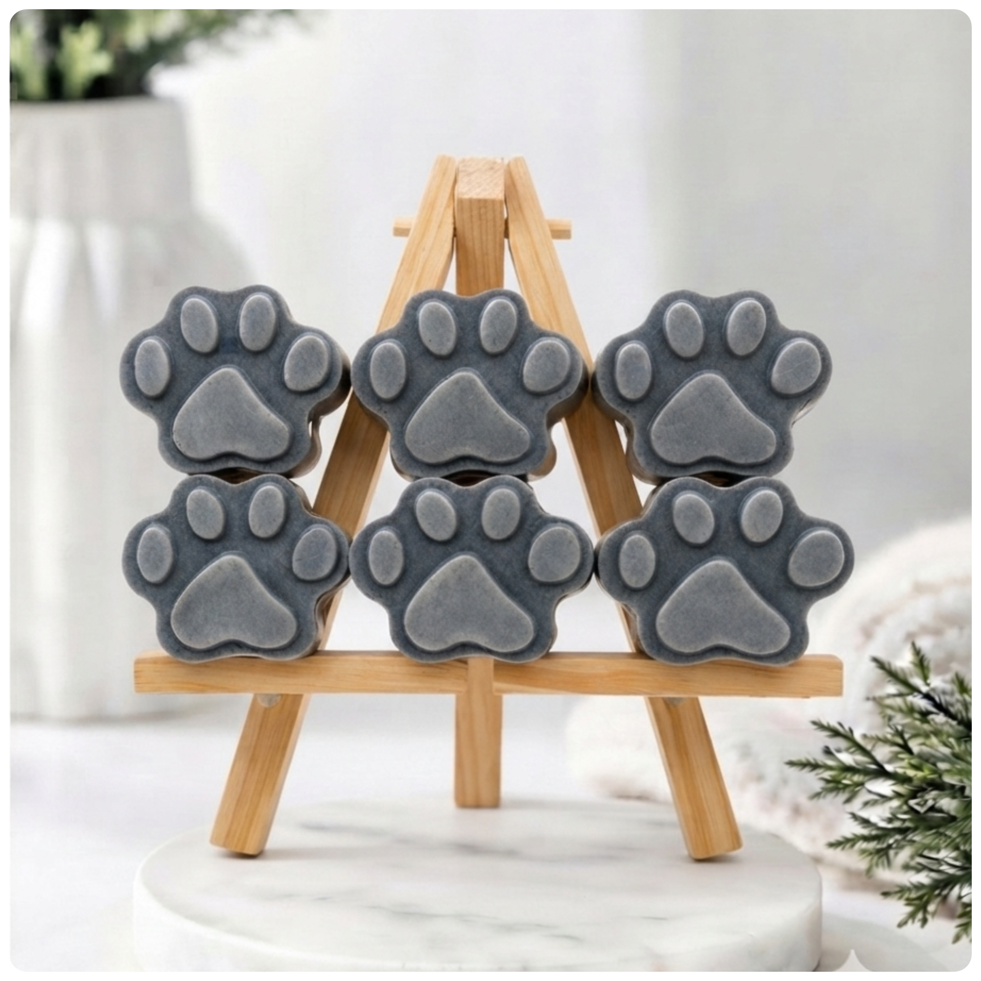 Gray paw-shaped vegan soap gift set on wooden stands with a light background
