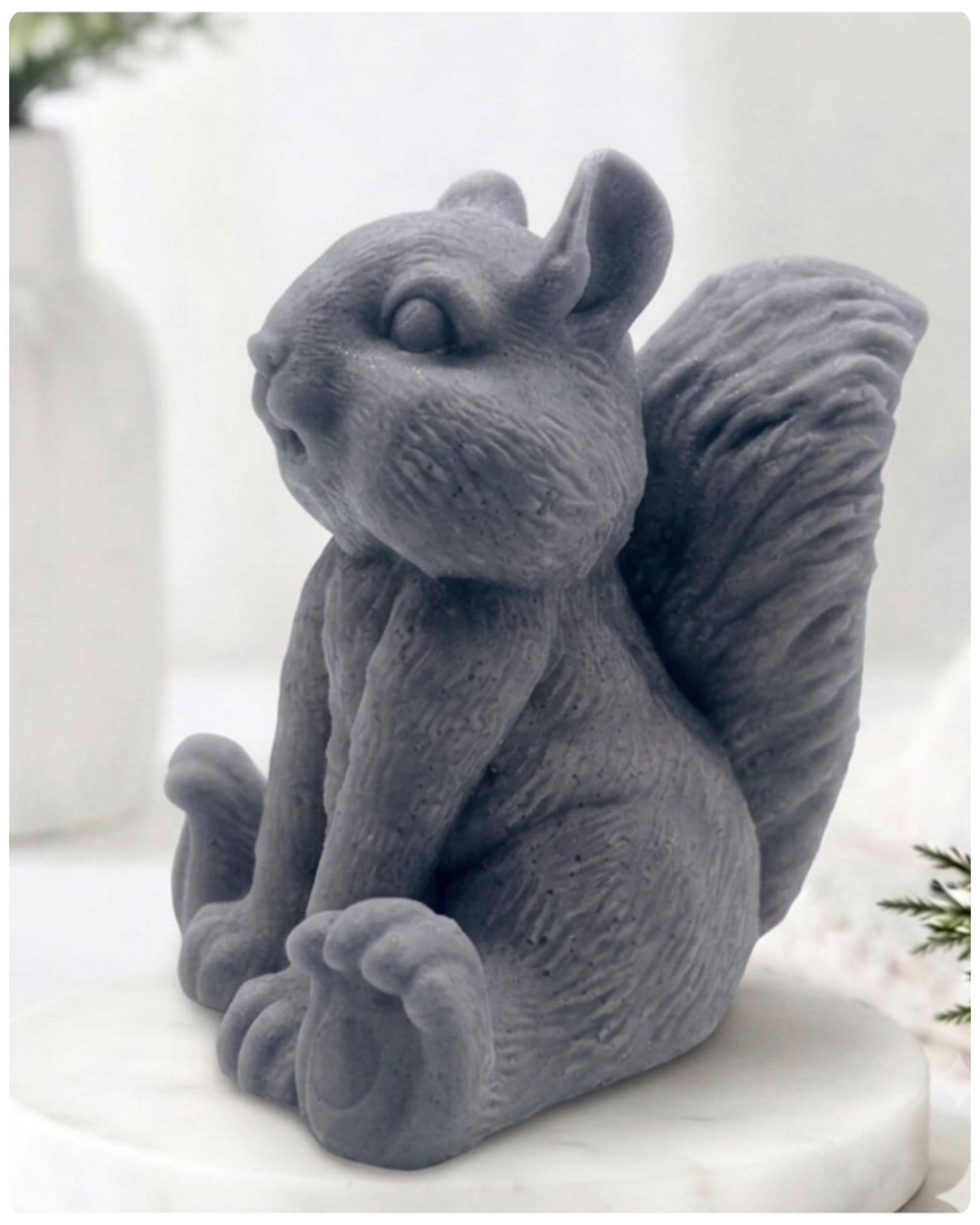 Handmade 3D squirrel-shaped soap sitting upright on a white marble display stand, featuring detailed textured fur and a bushy tail.