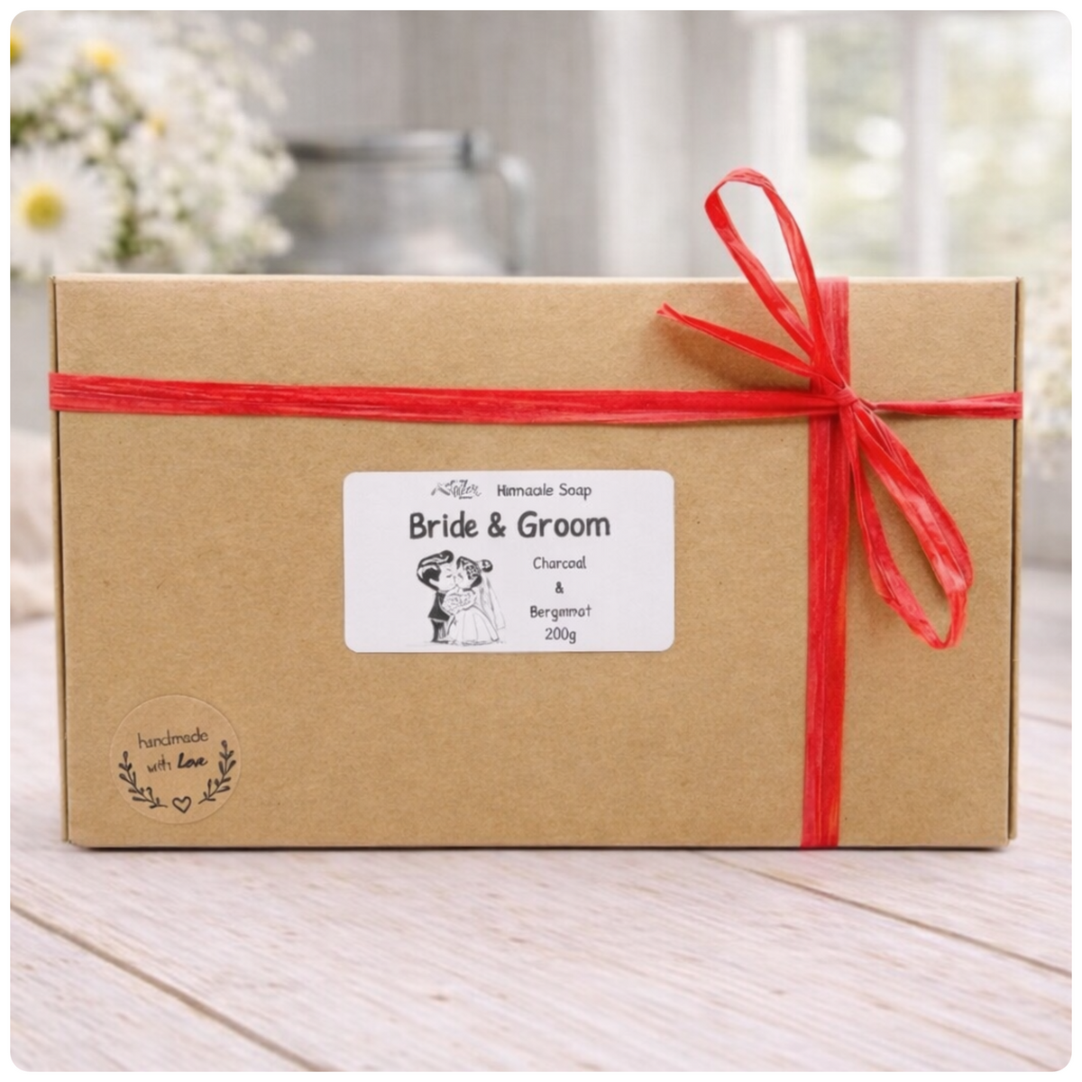 Gift box with 'Bride & Groom' label and red ribbon on a wooden surface.