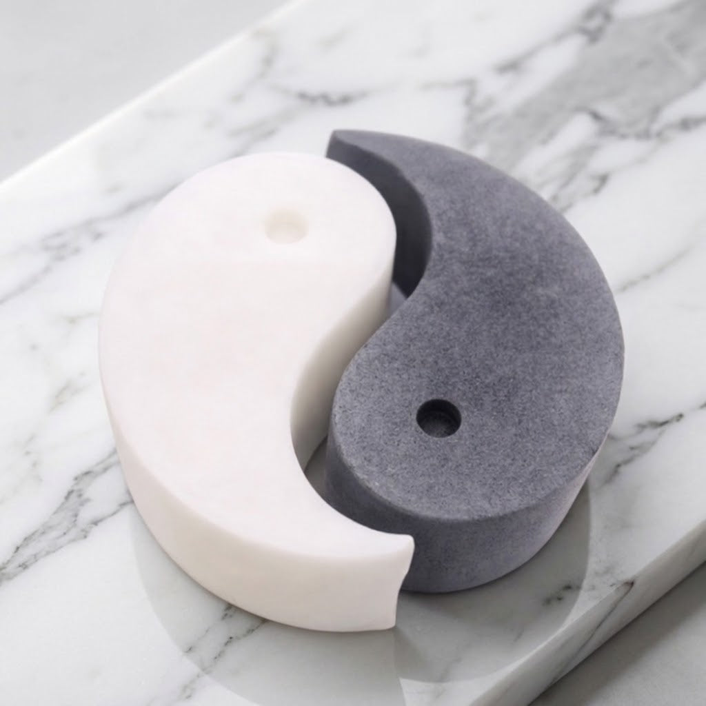 A handmade vegan soap gift set featuring two interlocking teardrop-shaped bars in contrasting black and white to form a large yin and yang symbol, displayed on a light wooden surface.