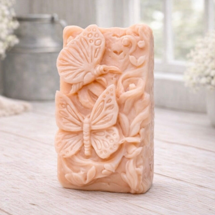 Decorative vegan soap bar with butterfly design on a wooden surface