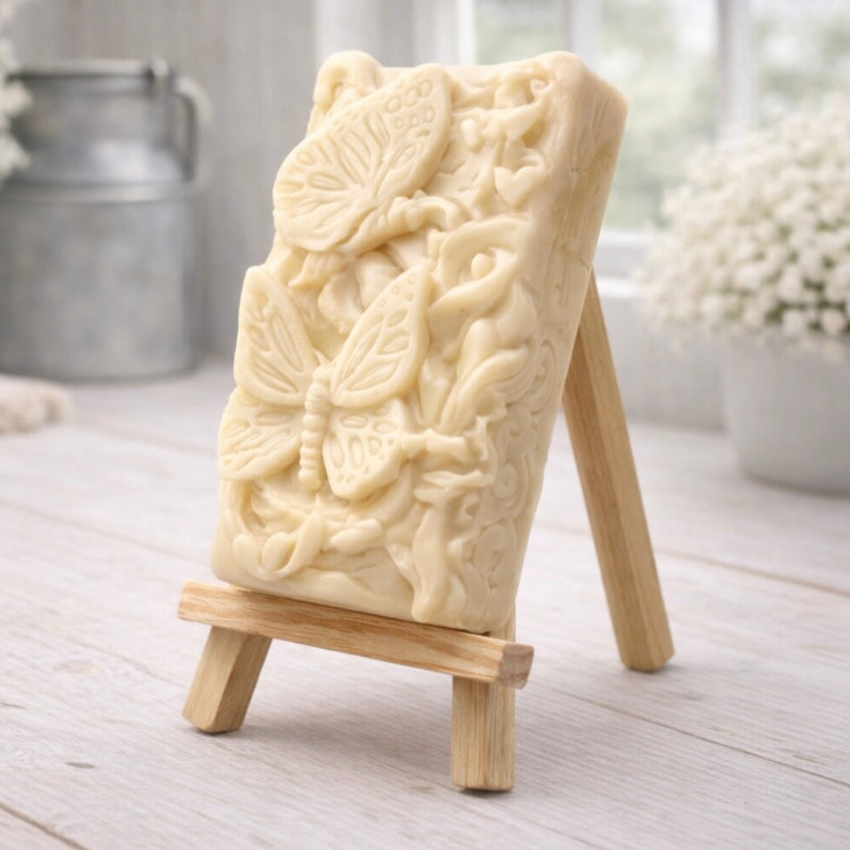 Decorative vegan soap with detailed butterfly relief design on a wooden stand in a home setting