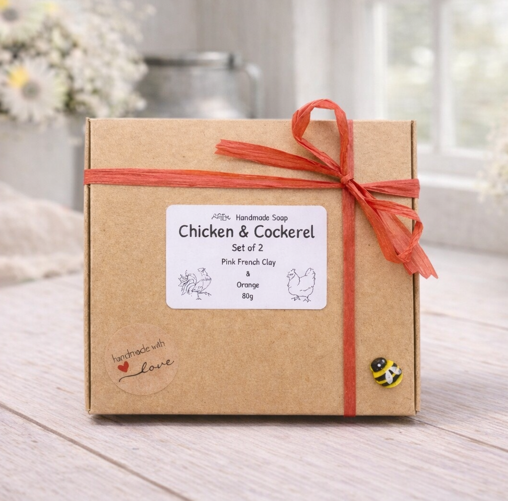 Box of Chicken & Cockerel soap set with a red ribbon on a wooden surface.