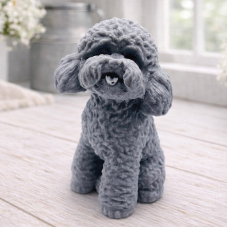 handmade vegan soap in the shape of a realistic sitting cockapoo or poodle sculpture, featuring detailed curly fur texture and a classic poodle groom, displayed on a rustic white wooden surface in a bright farmhouse decor setting.