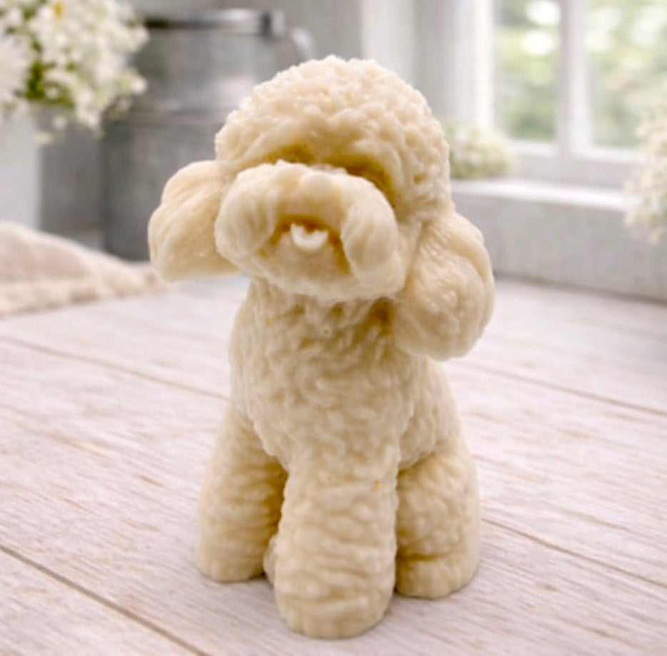 handmade vegan soap in the shape of a realistic sitting cockapoo or poodle sculpture, featuring detailed curly fur texture and a classic poodle groom, displayed on a rustic white wooden surface in a bright farmhouse decor setting.
