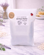 Load image into Gallery viewer, handmade vegan soap featuring a detailed 3D relief of various dog breeds sitting in a row with the text "all paws matter," displayed on a wooden easel against a rustic farmhouse decor background.
