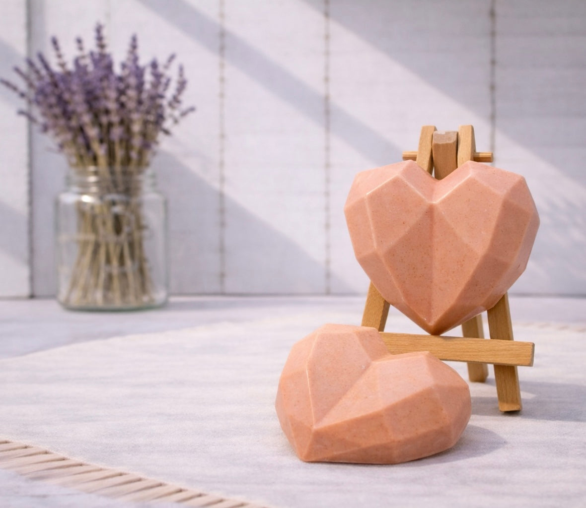 Geometric heart-shaped vegan soaps on a stand with lavender in the background