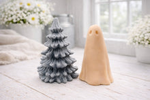 Load image into Gallery viewer, handmade ghost soap standing next to a grey textured Christmas tree sculpture soap, displayed on a rustic white wooden surface in a bright farmhouse decor setting.
