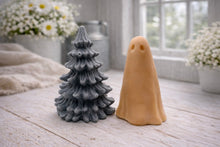 Load image into Gallery viewer, handmade ghost soap standing next to a grey textured Christmas tree sculpture soap, displayed on a rustic white wooden surface in a bright farmhouse decor setting.
