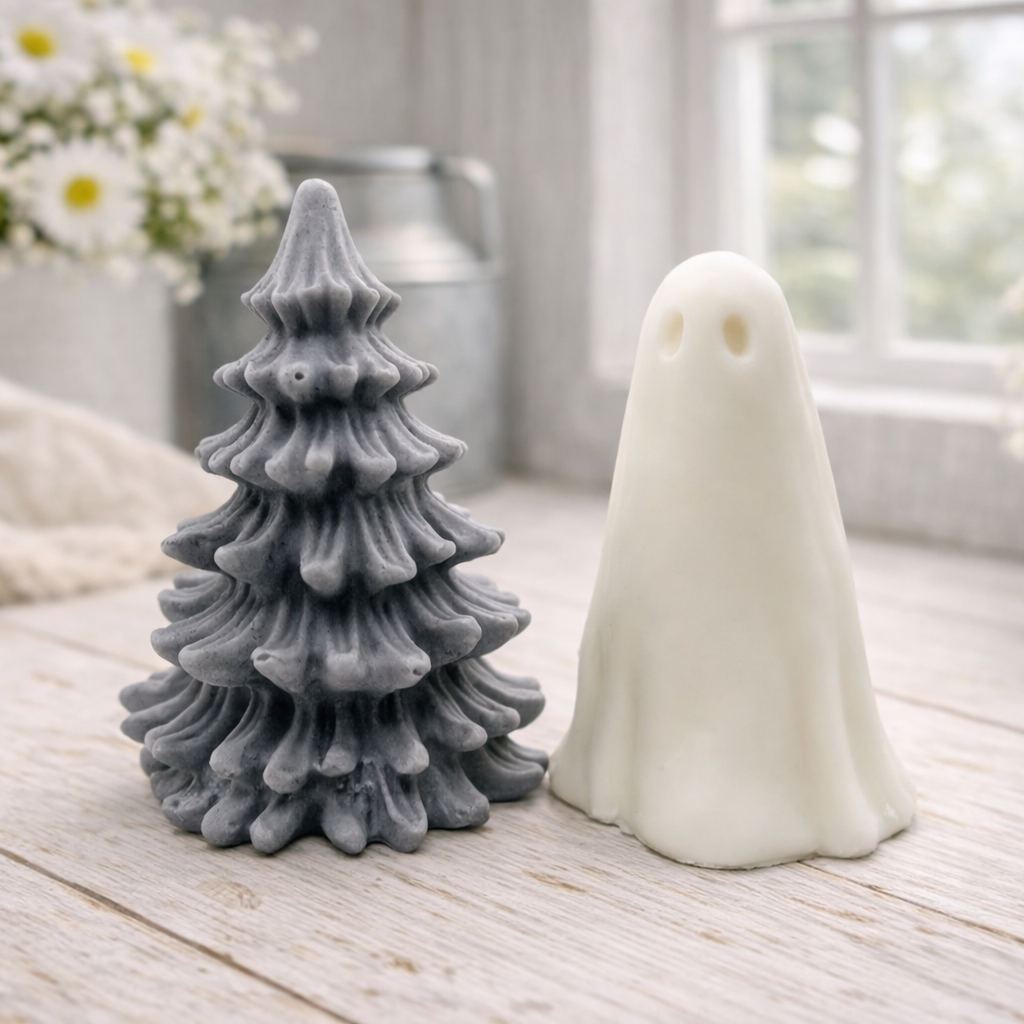 handmade ghost soap standing next to a grey textured Christmas tree sculpture soap, displayed on a rustic white wooden surface in a bright farmhouse decor setting.