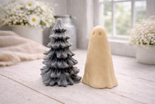 Load image into Gallery viewer, handmade ghost soap standing next to a grey textured Christmas tree sculpture soap, displayed on a rustic white wooden surface in a bright farmhouse decor setting.
