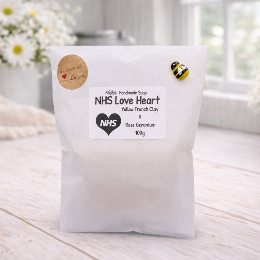 White bag labeled 'NHS Love Heart' on a wooden surface with flowers in the background