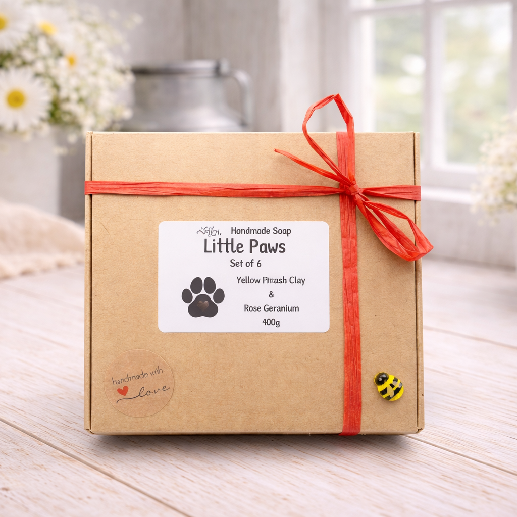 Handmade soap set packaging with a red ribbon on a wooden surface