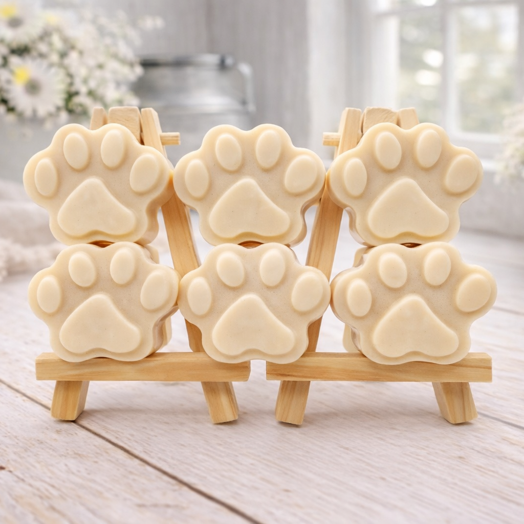 Set of dog paw-shaped vegan soaps on a wooden stand with a light background