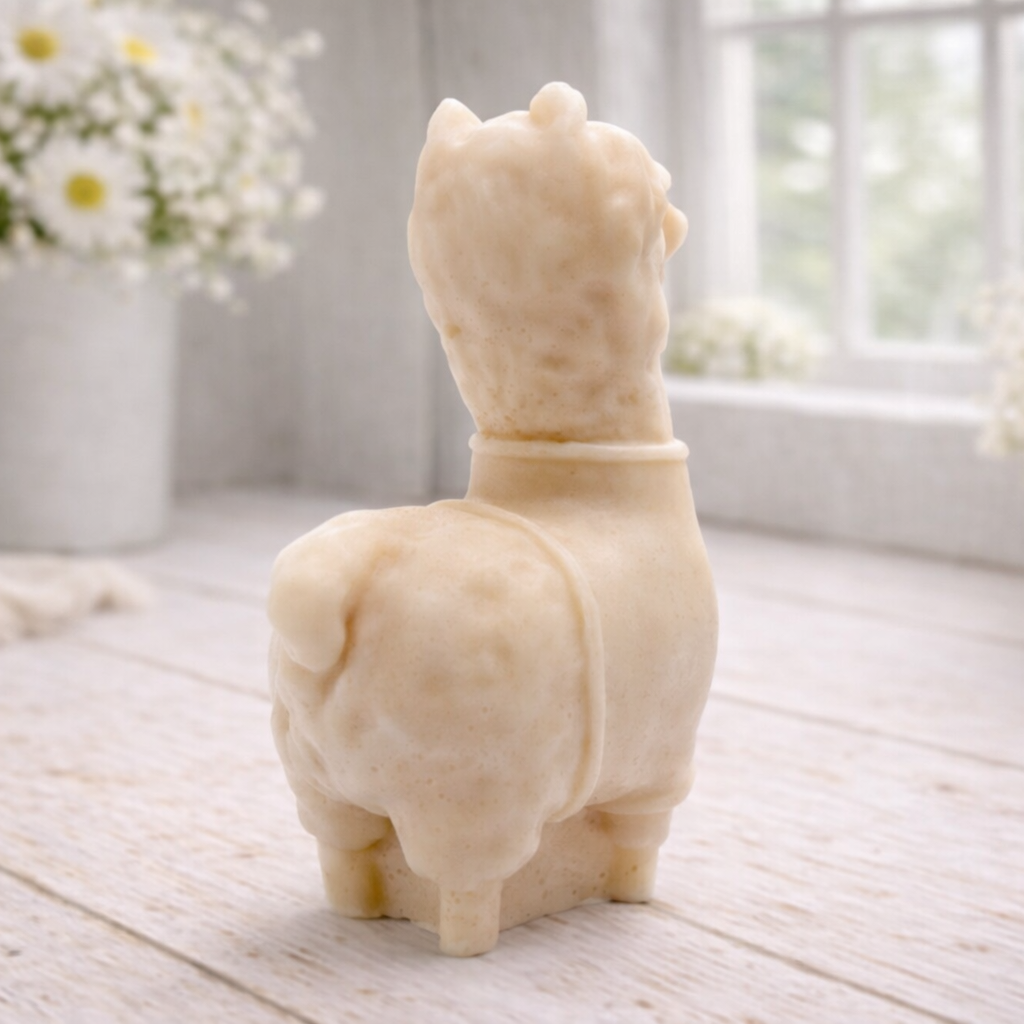 handmade vegan soap in the shape of a realistic standing alpaca or llama sculpture, featuring a smooth body with detailed fur texture on the head and neck, displayed in a bright farmhouse decor setting.