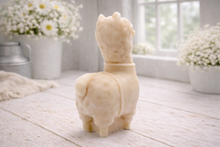 Load image into Gallery viewer, handmade vegan soap in the shape of a realistic standing alpaca or llama sculpture, featuring a smooth body with detailed fur texture on the head and neck, displayed in a bright farmhouse decor setting.
