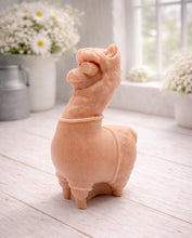 Load image into Gallery viewer, handmade vegan soap in the shape of a realistic standing alpaca or llama sculpture, featuring a smooth body with detailed fur texture on the head and neck, displayed in a bright farmhouse decor setting.

