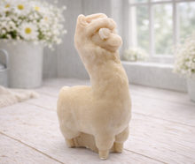 Load image into Gallery viewer, handmade vegan soap in the shape of a realistic standing alpaca or llama sculpture, featuring a smooth body with detailed fur texture on the head and neck, displayed in a bright farmhouse decor setting.

