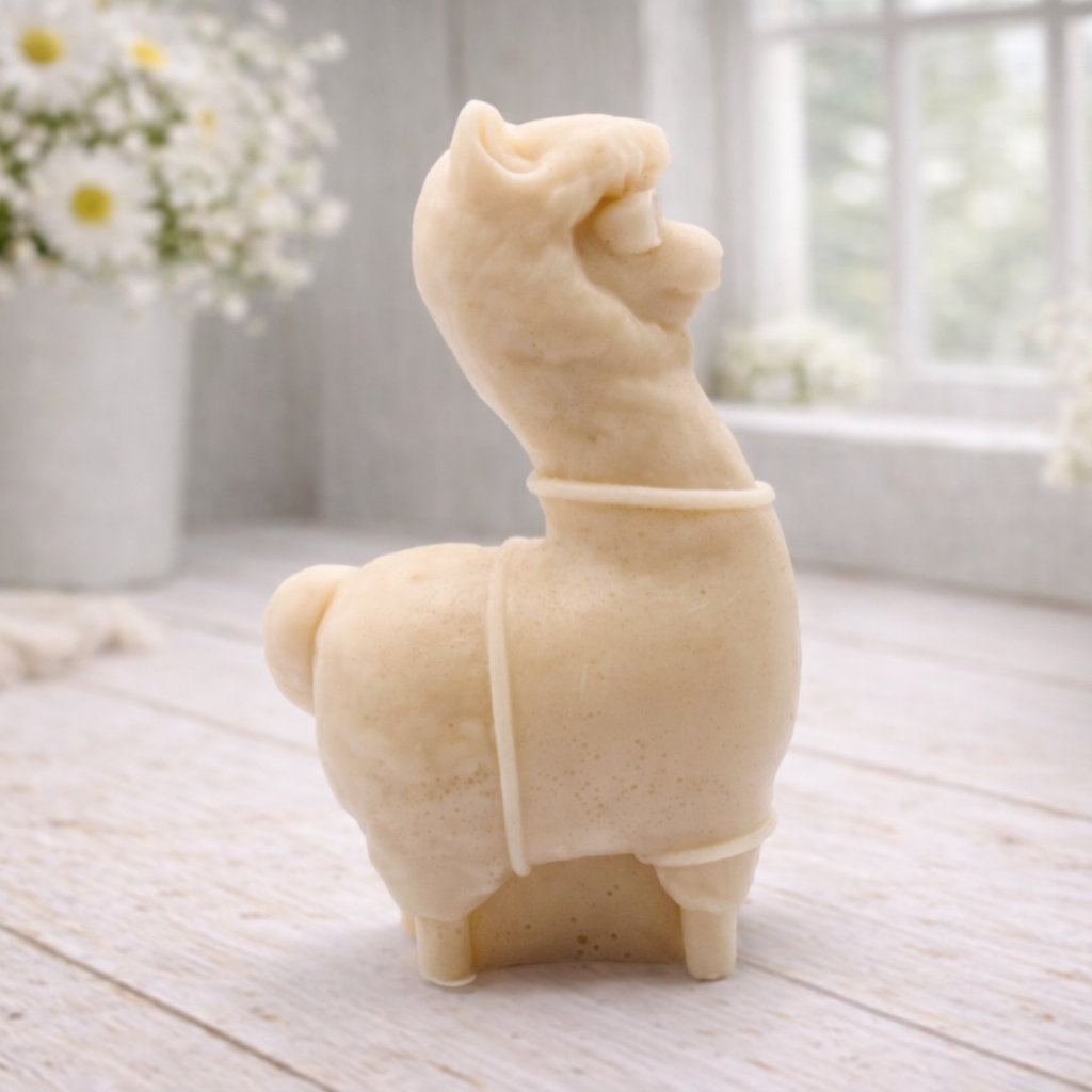 handmade vegan soap in the shape of a realistic standing alpaca or llama sculpture, featuring a smooth body with detailed fur texture on the head and neck, displayed in a bright farmhouse decor setting. handmade vegan soap in the shape of a realistic standing alpaca or llama sculpture, featuring a smooth body with detailed fur texture on the head and neck, displayed in a bright farmhouse decor setting.