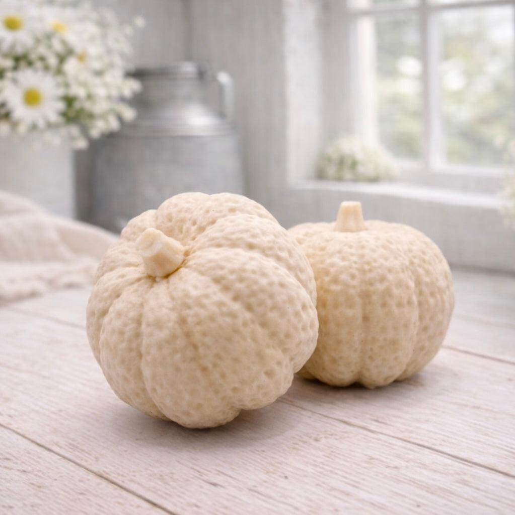 handmade vegan soaps in the shape of realistic chunky pumpkins, featuring detailed bumpy skin texture and stems, displayed on a rustic white wooden surface in a bright farmhouse decor setting.