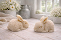 handmade vegan soaps in the shape of realistic crouching rabbits with detailed fur texture, displayed on a rustic white wooden surface in a bright farmhouse decor setting.
