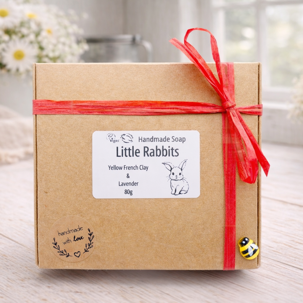 Handmade soap packaging with a red ribbon on a wooden surface