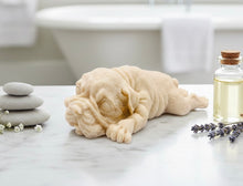 Load image into Gallery viewer, A highly detailed handmade vegan soap in a sophisticated slate-grey tone, sculpted in the shape of a Shar Pei puppy lying flat on its stomach with its head resting on its paws, featuring realistic deep skin folds and wrinkles.
