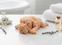 Load image into Gallery viewer, A highly detailed handmade vegan soap in a sophisticated slate-grey tone, sculpted in the shape of a Shar Pei puppy lying flat on its stomach with its head resting on its paws, featuring realistic deep skin folds and wrinkles.
