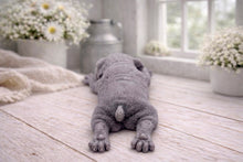 Load image into Gallery viewer, A highly detailed handmade vegan soap in a sophisticated slate-grey tone, sculpted in the shape of a Shar Pei puppy lying flat on its stomach with its head resting on its paws, featuring realistic deep skin folds and wrinkles.
