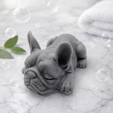 Load image into Gallery viewer, Handmade vegan soap in the shape of a realistic sleeping French Bulldog lying down, showing detailed ear texture and facial wrinkles, surrounded by bubbles in a marble bathroom setting.
