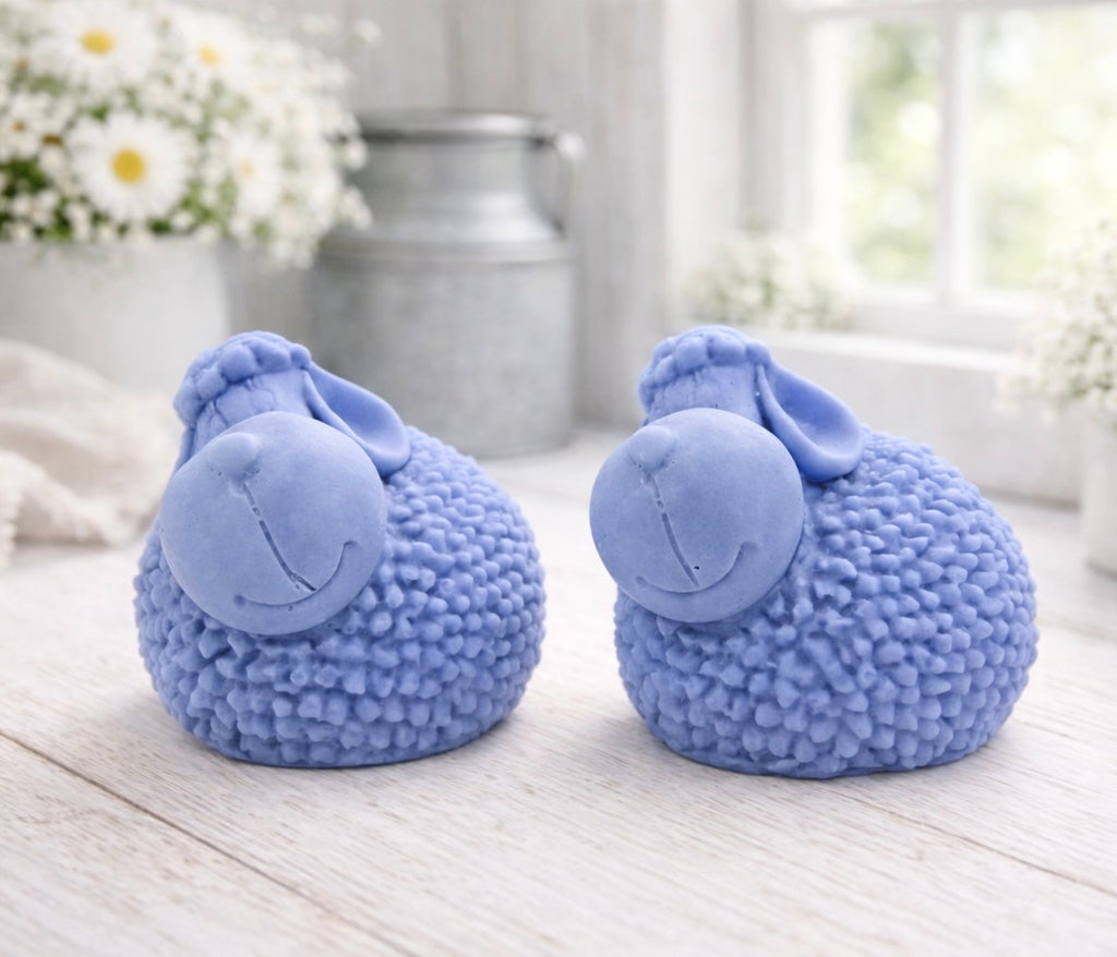 Two handmade vegan soap gift set featuring two fluffy spring lambs with detailed wool texture, displayed on a weathered white wooden surface in a bright farmhouse decor room