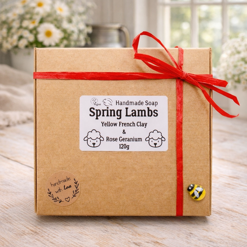Handmade soap packaging with a red ribbon on a wooden surface