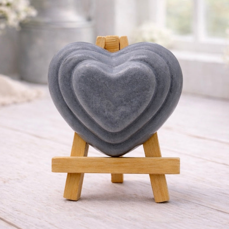 handmade vegan soap gift featuring a triple-tiered heart relief design, displayed on a wooden easel against a rustic farmhouse decor background with lavender.