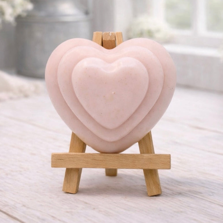 handmade vegan soap gift featuring a triple-tiered heart relief design, displayed on a wooden easel against a rustic farmhouse decor background with lavender.