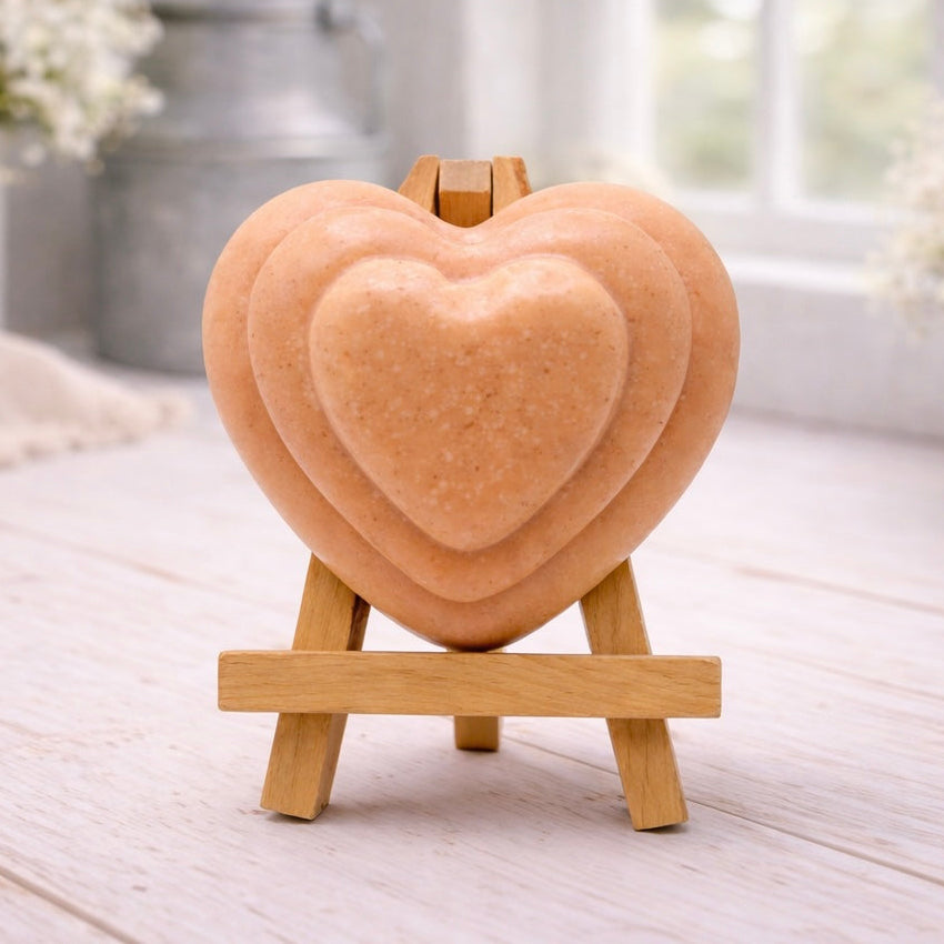 handmade vegan soap gift featuring a triple-tiered heart relief design, displayed on a wooden easel against a rustic farmhouse decor background with lavender.