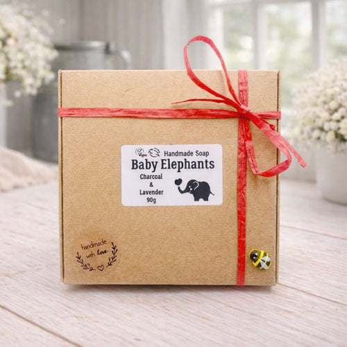 Handmade soap packaging with 'Baby Elephants' label on a wooden surface