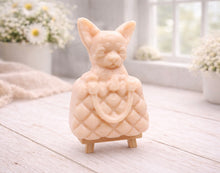 Load image into Gallery viewer, A highly detailed handmade vegan soap in a speckled grey marble finish, sculpted as a small chihuahua puppy with large ears peeking out from inside a quilted designer-style handbag, displayed on a miniature wooden easel.

