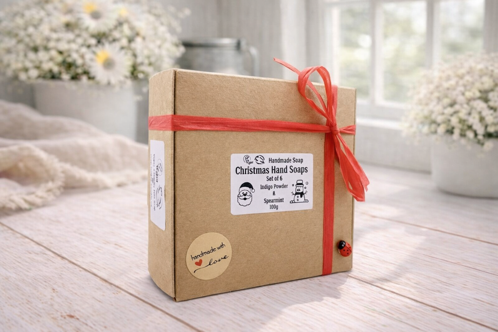 Box of Christmas hand soaps with a red ribbon on a wooden surface