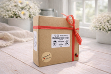 Load image into Gallery viewer, Box of Christmas hand soaps with a red ribbon on a wooden surface
