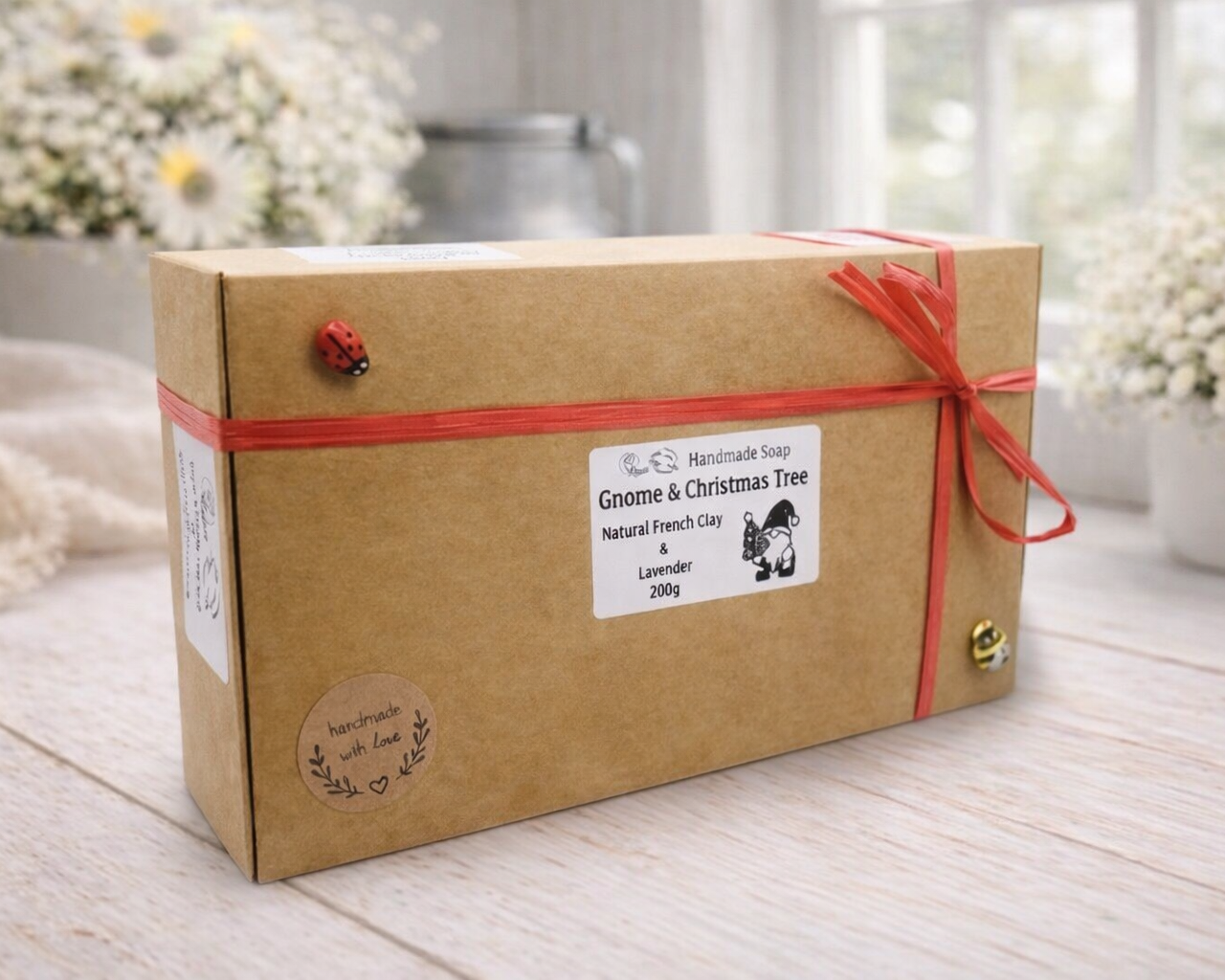 Kraft paper box with red ribbon on a wooden surface with blurred flowers in the background