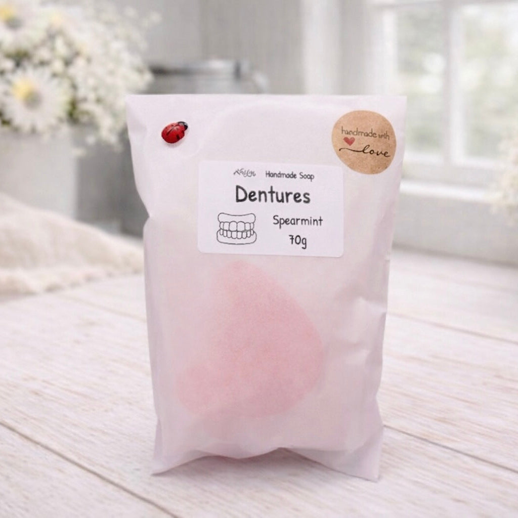 Packaged dentures soap with a label on a light wooden surface
