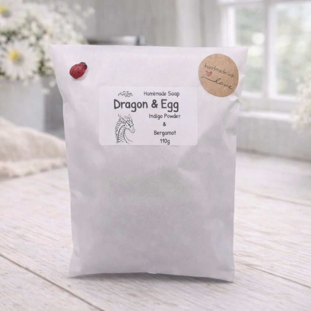 White bag labeled 'Dragon & Egg' on a wooden surface with flowers in the background