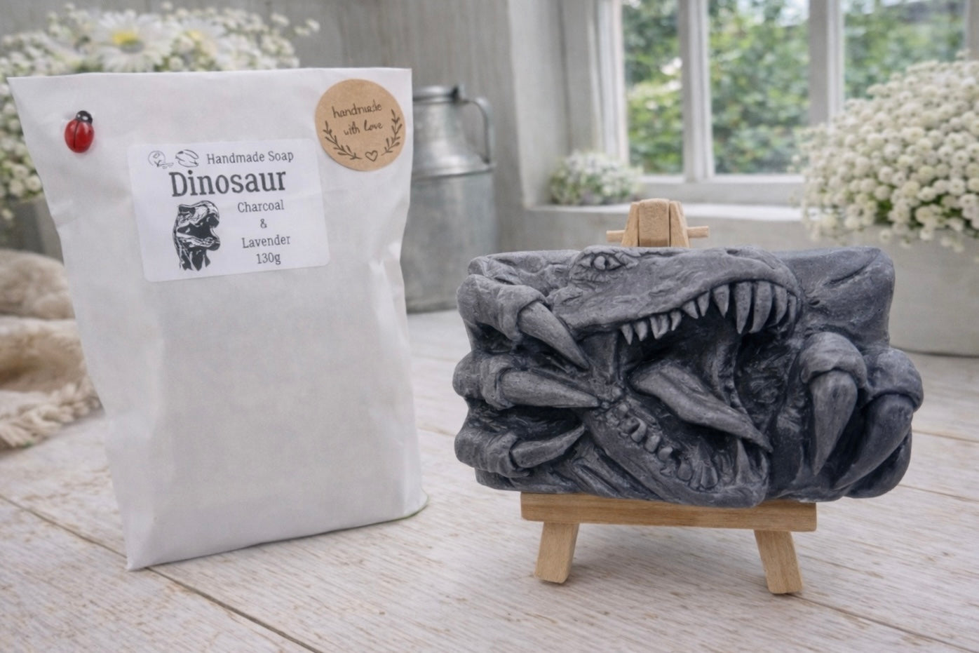 A rectangular handmade vegan soap  featuring a high-relief carving of a Tyrannosaurus Rex with its jaws wide open in a roar and sharp claws framing the face, displayed on a miniature wooden easel.