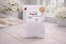 Load image into Gallery viewer, White bag of Dragonfly Pink French Clay Soap on a wooden surface with flowers in the background
