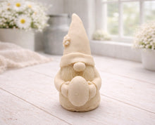 Load image into Gallery viewer, A detailed handmade vegan soap gift,  sculpted as a whimsical Easter gnome (gonk) wearing a tall pointed hat with a flower detail, holding a large patterned Easter egg.
